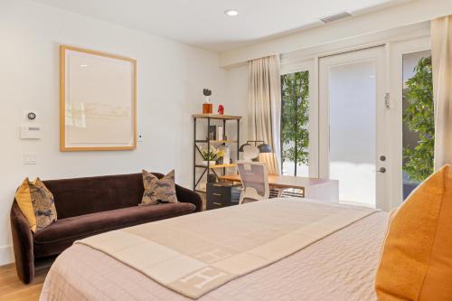 a bedroom with a bed and a couch and a table at @ Marbella Lane - 4BR Mediterranean-style Home in Newport Beach