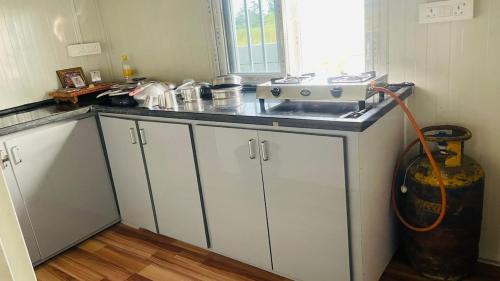 a kitchen with a counter top with a vacuum at Aasa Farmhouse in Hyderabad