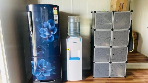 a refrigerator and a water cooler next to a water container at Aasa Farmhouse in Hyderabad