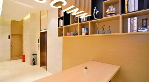 une chambre avec une table et une étagère avec des livres dans l'établissement City Comfort Inn Kunming High-speed Railway South Station 7th Street Area, à Kunming