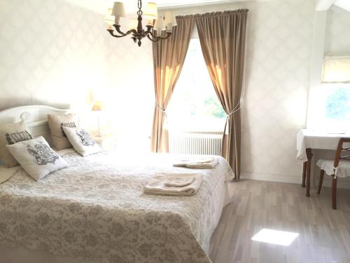 - une chambre avec un lit, une fenêtre et un lavabo dans l'établissement Villa Granvik, à Söderfors