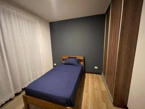 a bedroom with a blue bed in a room at Cómodo y acogedor departamento amoblado in Cochabamba