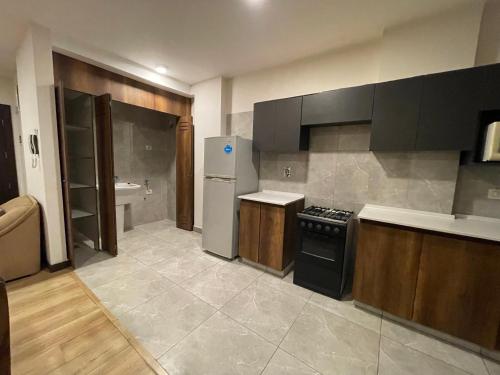 a kitchen with a stove and a refrigerator at Cómodo y acogedor departamento amoblado in Cochabamba