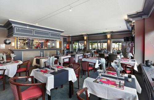 a restaurant with tables and chairs and a bar at The Originals City Hotel de l Ange Guebwiller in Guebwiller