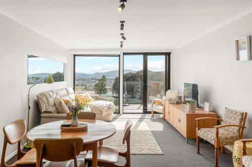 a living room with a table and chairs and a couch at 4onFour in Hobart