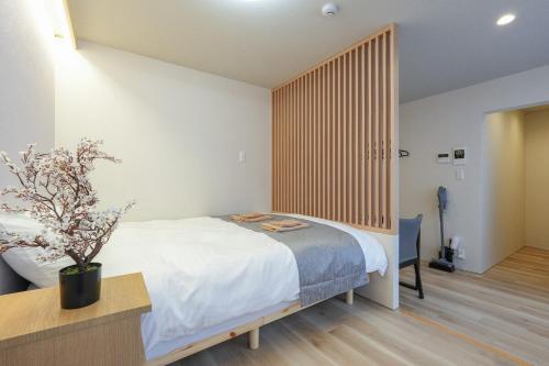 a bedroom with a large bed with a wooden headboard at Seed INN Haneda Terrace 101 in Tokyo