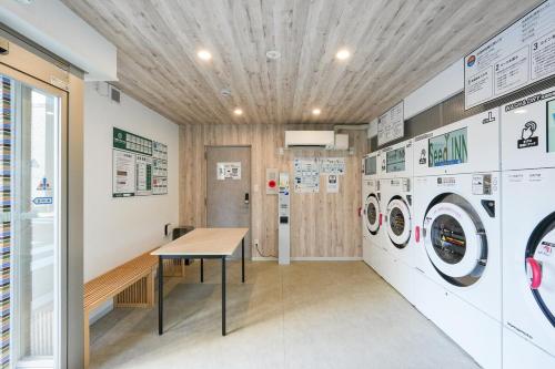 a laundry room with a table and washing machines at Seed INN Haneda Terrace 101 in Tokyo
