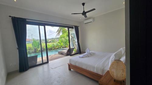 1 dormitorio con cama y ventana grande con vistas en Adyatma Ubud, en Ubud