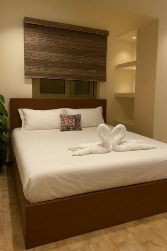 a bed with two swan towels on top of it at شقه فندقيهTv75-PS4حدايق الاهراماتPyramids in ‘Ezbet `Abd el-Ḥamîd