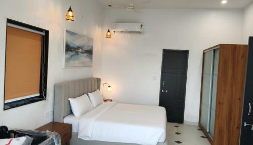 une chambre avec un lit blanc et une fenêtre dans l'établissement Pearl Pride Villa Udaipur, à Udaipur