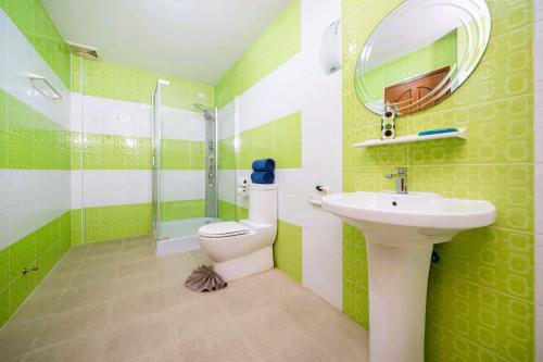 - une salle de bains verte et blanche avec toilettes et lavabo dans l'établissement Mediteranean style 3 BR Pool Villa Platinum with garden, à Rawai Beach