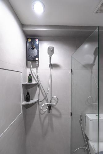 a bathroom with a shower with a phone on the wall at Near Don Mueang Hotel in Bangkok