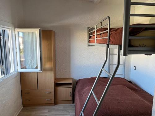 a small bedroom with a bunk bed with a ladder at Maisonnette privé bord de mer Poggio mezzana in Poggio-Mezzana