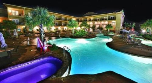 a resort with a large swimming pool at night at Holiday Inn Express & Suites Fredericksburg By IHG in Fredericksburg