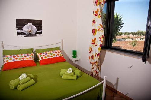 a bedroom with a green bed with two stuffed animals on it at Villa Rosalba in Polignano a Mare