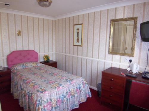 1 dormitorio con cama, tocador y espejo en Old Lamb Hotel en Reading