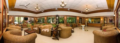 a large room with chairs and tables and windows at Ideal Beach Resort in Mahabalipuram