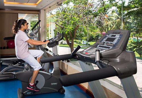 a woman riding an exercise bike on a treadmill at Ideal Beach Resort in Mahabalipuram