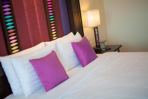 a bedroom with a bed with purple and white pillows at Huernnana Boutique Hotel in Phrae