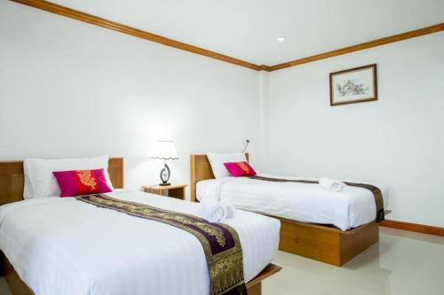 two beds in a room with white and pink pillows at Thatphanom View Hotel Nakhon in Ban Nong Hoi