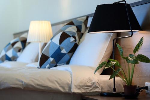 a lamp sitting on a table next to a bed at 雲起軒民宿 Cloudscape B&B in Jian