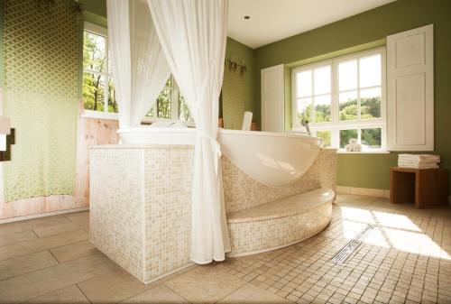ein Badezimmer mit Badewanne und Waschbecken in der Unterkunft Schloss Basthorst in Crivitz
