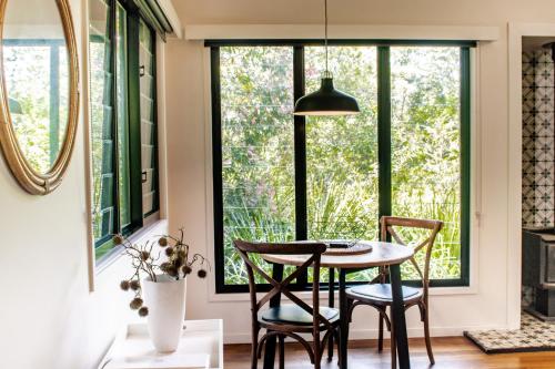 a dining room with a table and chairs in front of a window at Tallaringa Views in Alstonville