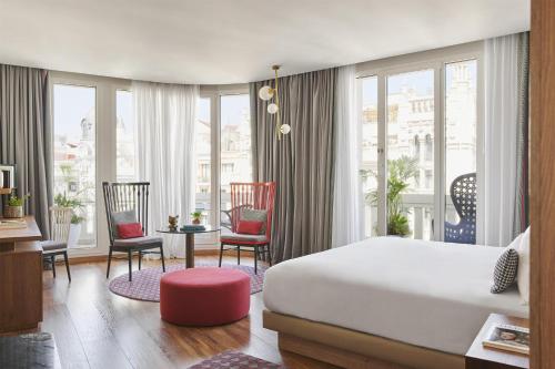 a bedroom with a bed and a table and chairs at Hyatt Centric Gran Via Madrid in Madrid