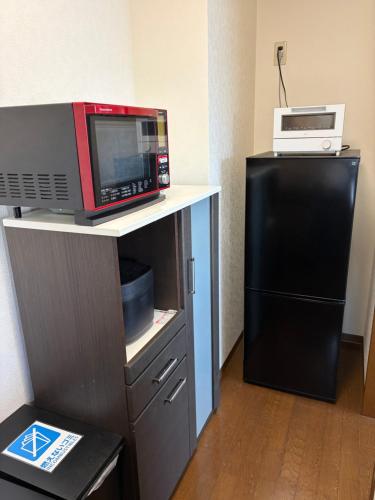 a microwave and a refrigerator in a room at STAYMoiwayama in Sapporo