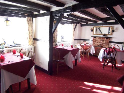 a restaurant with tables and chairs in a room at Old Lamb Hotel in Reading