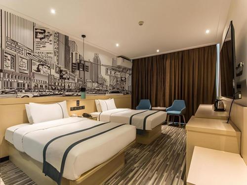 a hotel room with two beds and a desk at City Comfort Inn Guilin Railway Station in Guilin