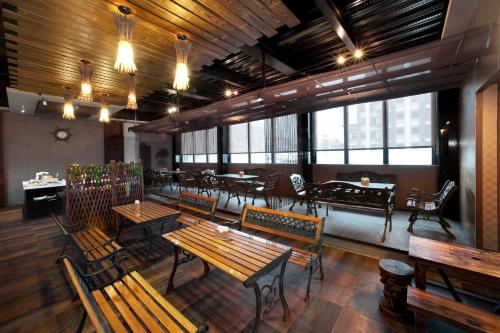a restaurant with wooden benches and tables and windows at One Fukun Hotel in Jiaoxi