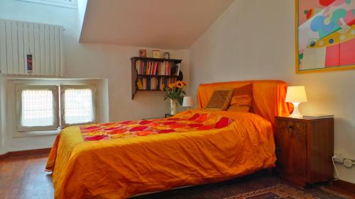 ein Schlafzimmer mit einem Bett mit einer orangefarbenen Bettdecke in der Unterkunft AleEle Flexyrent aircon e WiFi in Mailand