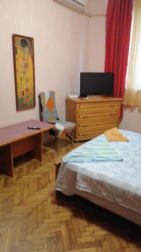 a bedroom with a bed and a dresser and a desk at апартамент Климент in Varna City