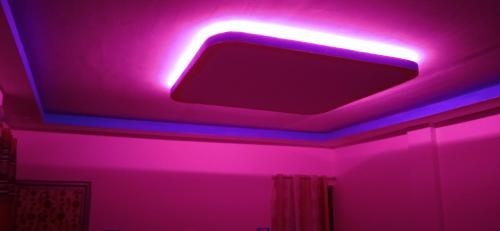 Risingresort في Jāmb: غرفة مع ضوء وردي على السقف