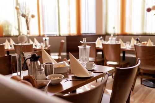 een eetkamer met houten tafels en stoelen bij Best Western Hotel Ambassador in Baunatal