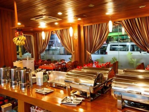 a restaurant with a counter with silver food at Asia Hotel in Phnom Penh