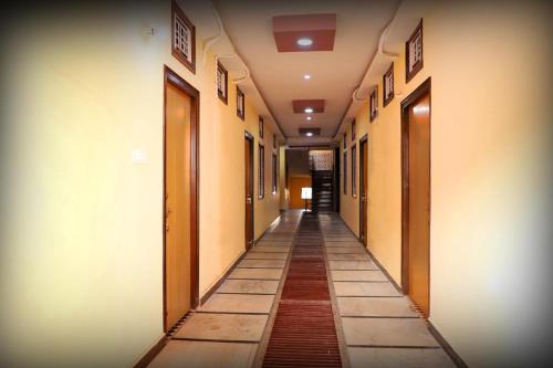 an empty hallway of a building with doors and a tile floor at Hotel Krishna Gorakhpur in Gorakhpur
