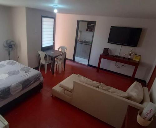 a living room with a couch and a bed and a table at Flowers House Aptos - Centro Histórico in Valledupar