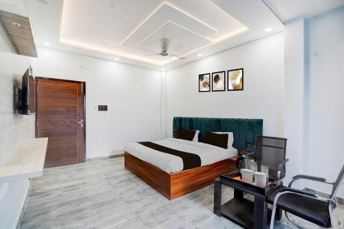 Un dormitorio con una cama y un televisor en una habitación. en Super Hotel O Hanuman Gadi Formerly Alankar Lawn, en Varanasi