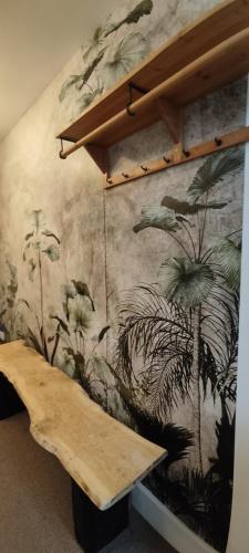 a mural on a wall with a wooden bench at Cheltenham town centre with parking space in Cheltenham
