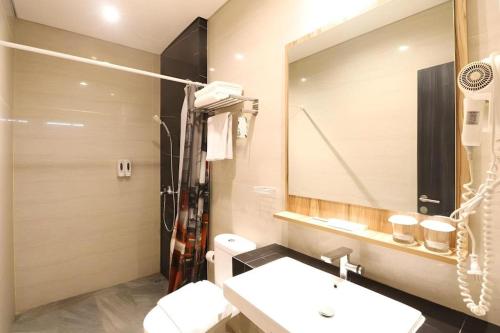 a bathroom with a sink and a mirror at Fitra Hotel Majalengka in Majalengka