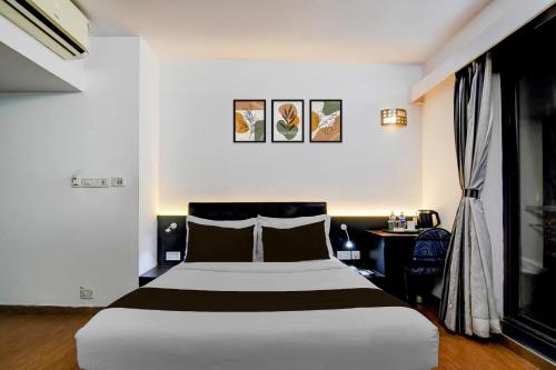 a hotel room with a large bed and a desk at Townhouse Oak Ballygunge Formerly Hotel Lovelock in Ballygunge