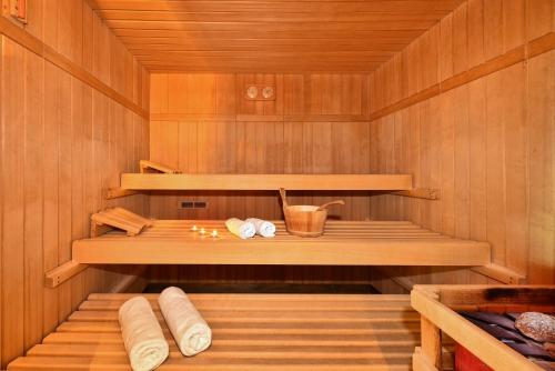 a sauna with wooden walls and wooden shelves and a table at Panoramahotel Obkircher in Nova Ponente