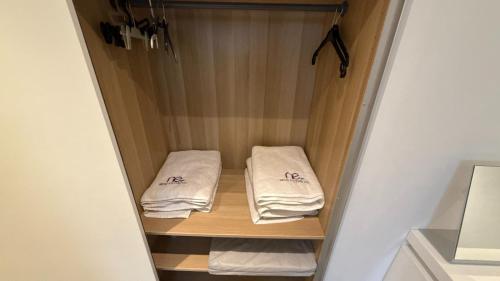 a small closet with two towels on a shelf at Appartement 5 personne avec accès piscine jacuzzi disponibilité saisonnière in Villers-la-Ville