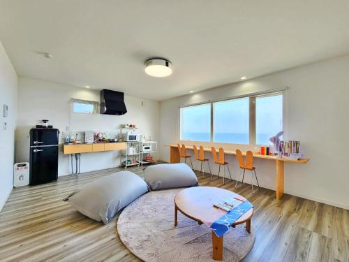 a living room with a couch and a table at 「淡路島一棟貸宿　野うさぎ 」高台から海を望む貸別荘！2023年新築離れの素泊まり in Noda