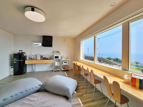 a living room with chairs and a large window at 「淡路島一棟貸宿　野うさぎ 」高台から海を望む貸別荘！2023年新築離れの素泊まり in Noda