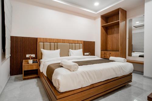 een slaapkamer met een groot bed met witte lakens bij Hotel SK Elite in Jodhpur