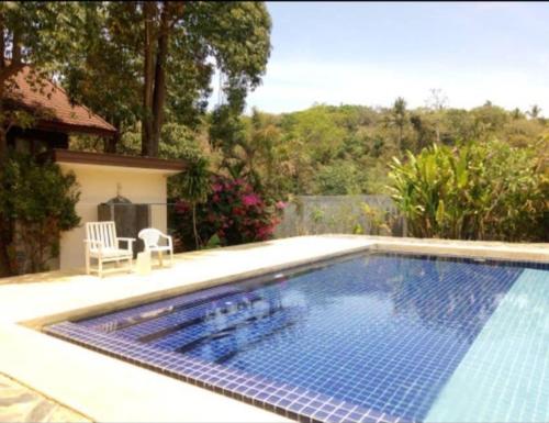 ein großer Pool in einem Hof mit einem Haus in der Unterkunft ลันตาไวท์ร็อค รีสอร์ท in Ban Nong Chaeng