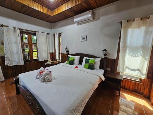 ein Schlafzimmer mit einem großen Bett mit Stofftieren darauf in der Unterkunft ลันตาไวท์ร็อค รีสอร์ท in Ban Nong Chaeng